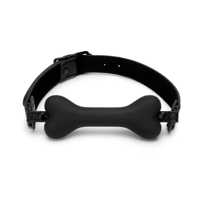 Black bone-shaped silicone gag with adjustable leather strap and buckle closure on white background.