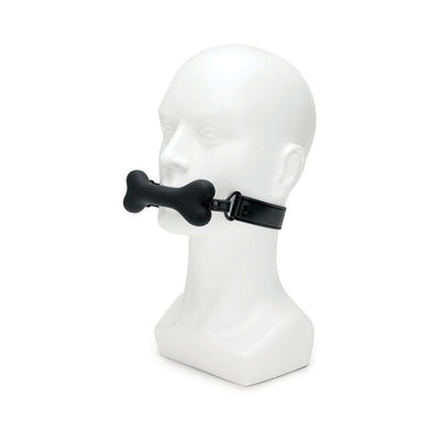 Black bone-shaped silicone gag with adjustable strap displayed on white mannequin head.