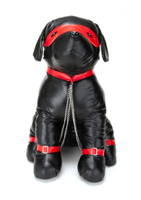 Black leather dog-shaped cushion with red collar, eye mask, leg straps, and attached silver chains.