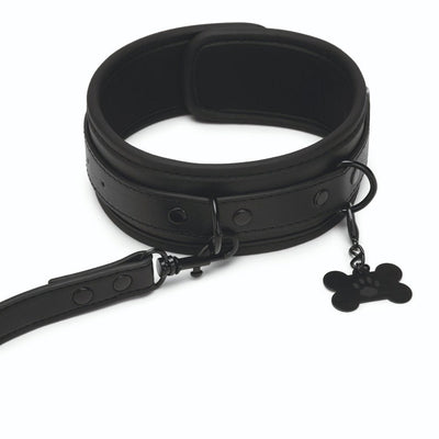 Black faux leather collar and leash set with adjustable buckle and bone-shaped charm with paw print.