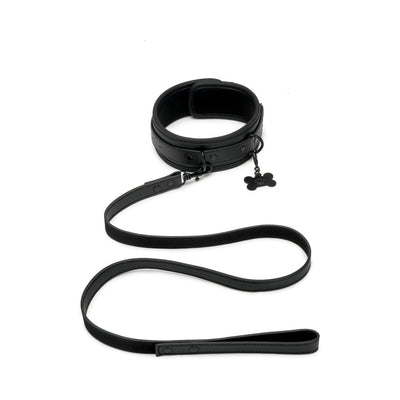 Black faux leather collar and leash set with adjustable buckle and bone-shaped charm on collar.