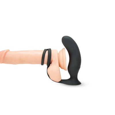 Black ergonomic prostate massager with dual C-ring attachment displayed on a realistic silicone model.