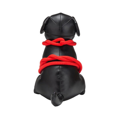 Black leather dog figure tied with bright red bondage rope viewed from behind on white background