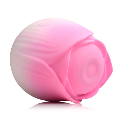 Pink rose-shaped pulsing stimulator made of smooth silicone with a petal design and a power button on top.