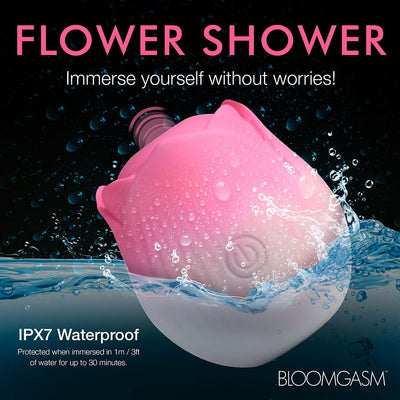 Pink and white rose-shaped waterproof stimulator partially submerged in water with water droplets on its surface.