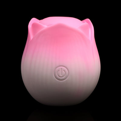 Pink and white rose-shaped pulsing stimulator with power button on front, made of smooth silicone.