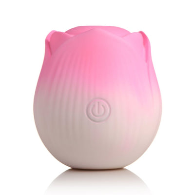 Pink and white rose-shaped pulsing stimulator with power button on front, made of smooth silicone.