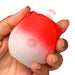 Hand holding a small red and white rose-shaped pulsing stimulator with a power button on the front.
