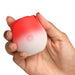 Hand holding a compact red and white rose-shaped pulsing stimulator with a power button on the front.