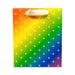 Rainbow gradient gift bag with white leaf pattern and white ribbon handles with gold grommets.