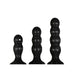 Set of three black silicone butt plugs in graduated sizes with rounded, segmented shapes and suction cup bases.