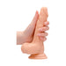 Hand holding a 7-inch vanilla-colored realistic dildo with detailed texture and suction cup base.