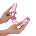 Hands holding a flexible, translucent pink double-ended dildo with realistic detailing.