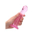 Hand holding a pink crystal clear non-realistic dildo with suction cup base on white background.
