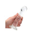 Hand holding a clear, non-realistic dildo with a suction cup base against a white background.