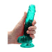 Hand holding a 7-inch crystal clear teal realistic dildo with suction cup base and detailed texture.