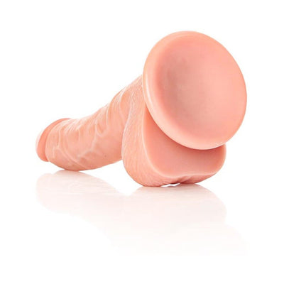 Curved realistic dildo with textured shaft, attached balls, and suction cup base in flesh tone.