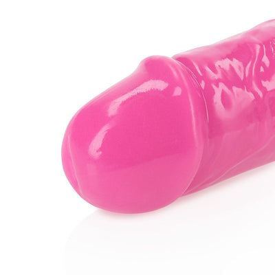 Close-up of the neon pink tip of a glow-in-the-dark dual-ended dildo with a smooth, glossy finish.