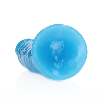Blue glow-in-the-dark slim dildo with suction cup base lying on its side on a white background.
