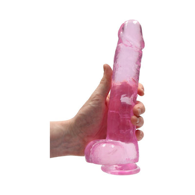 Hand holding a 9-inch translucent pink realistic dildo with suction cup base and textured details.