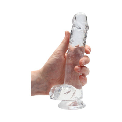 Hand holding a clear, realistic 8-inch dildo with suction cup base and detailed texture.