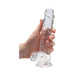 Hand holding a clear, realistic 8-inch dildo with suction cup base and detailed texture.