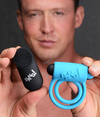Man holding a blue vibrating silicone cock ring and a black remote control with Bang! branding.