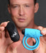 Man holding a blue vibrating silicone cock ring and a black remote control with Bang! branding.