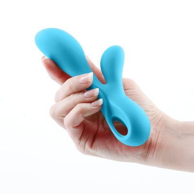 Hand holding a blue silicone dual stimulator with ergonomic design and finger loop for easy grip.