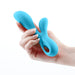 Hand holding a blue silicone dual stimulator with ergonomic design and finger loop for easy grip.