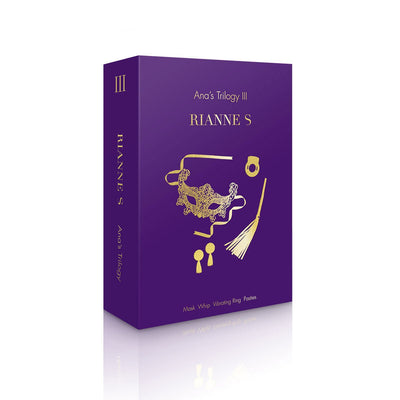 Purple box packaging of Rianne S Ana's Trilogy Kit 3 featuring gold illustrations of a mask, whip, vibrating ring, and pasties.