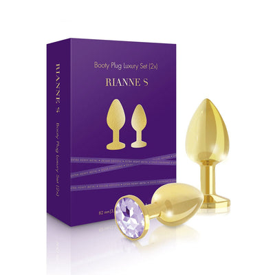 Rianne S luxury gold-plated metal booty plug set with purple gem accents and purple packaging box.