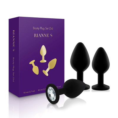Set of three black silicone booty plugs with gem-like bases displayed next to purple Rianne S packaging box.