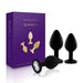Set of three black silicone booty plugs with gem-like bases displayed next to purple Rianne S packaging box.