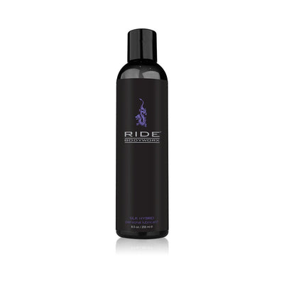 Black bottle of Ride Bodyworx Silk Hybrid personal lubricant with purple logo and text on a white background.