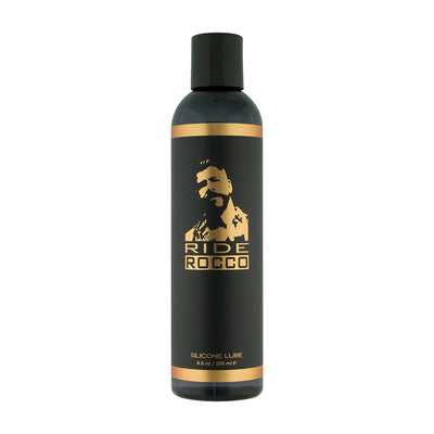 Black and gold 8.5oz bottle of Ride Rocco silicone lubricant with a stylized male portrait on the label.