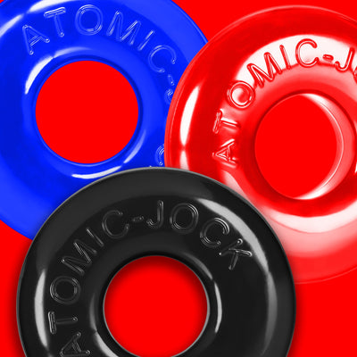 Three colorful OxBalls Ringer Max rubber rings in blue, red, and black on a red background.