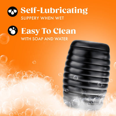Black ribbed self-lubricating stroker with soap bubbles on orange background highlighting easy cleaning.
