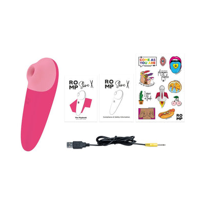Pink ROMP Shine X personal massager with USB charging cable, user guides, and colorful sticker sheet on white background.