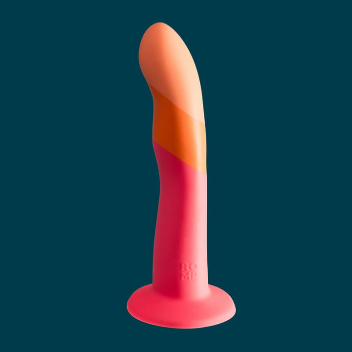 Curved pink and orange silicone toy with suction base designed for targeted internal stimulation.