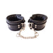 Black padded leather wrist cuffs connected by a detachable silver chain with trigger hooks and adjustable buckle straps.