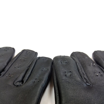 Close-up of black genuine leather gloves with small spikes on each finger, designed for a snug fit with elasticated wristbands.