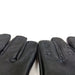 Close-up of black genuine leather gloves with small spikes on each finger, designed for a snug fit with elasticated wristbands.