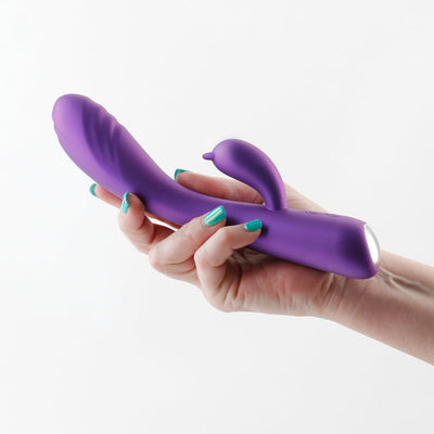 Hand holding a metallic purple Royals Duchess Rabbit Vibrator with a curved shaft and clitoral stimulator.