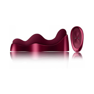 Ruby Glow Rosa Saddle Vibrator in deep red with ergonomic curves and matching remote control on white background.