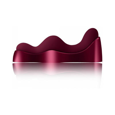 Ruby Glow Rosa Saddle Vibrator in deep rose color with ergonomic wave design and smooth finish on reflective surface.