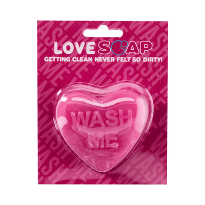 Pink heart-shaped soap bar with "WASH ME" embossed, packaged on a matching pink card with playful text.