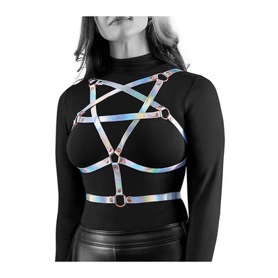 Rainbow holographic chest harness with rose gold hardware worn over a black long-sleeve top and leather pants.