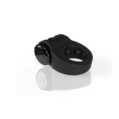 Black rechargeable silicone vibrating cock ring with textured motor and three-speed settings on a reflective surface.