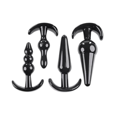 Set of four black glossy anal plugs in varying shapes and sizes with curved bases for safe use.